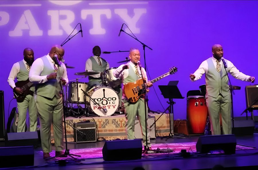 The group performing in a concert hall